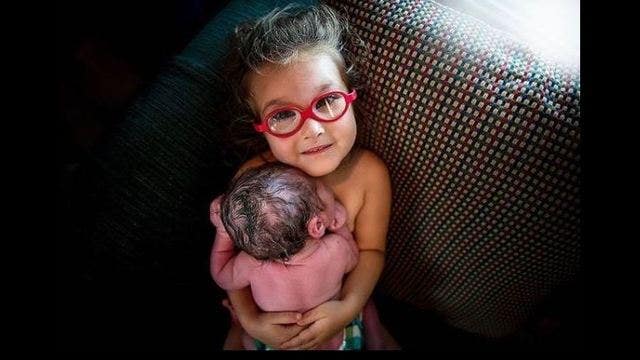 Proud big sister shares skin-to-skin moment with newborn brother