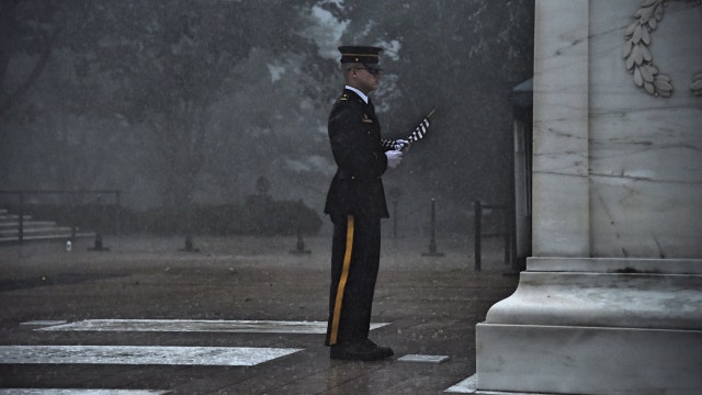 Soldier seen placing flag at Tomb of Unknown Soldier during torrential rain