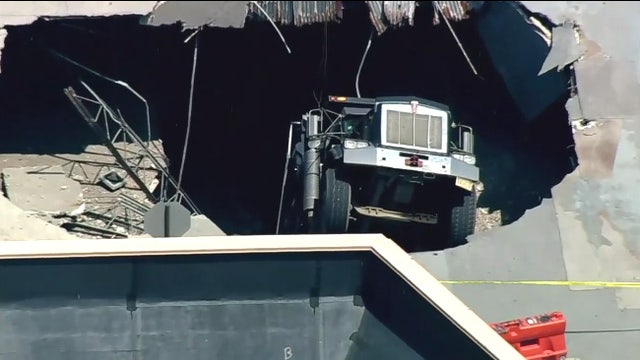 Dump truck falls through parking garage roof