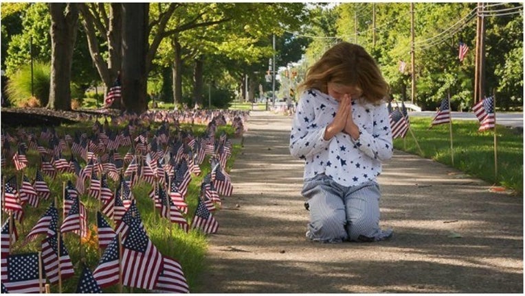 386ecdd3-little girl prays at memorial_1473846970191.jpg