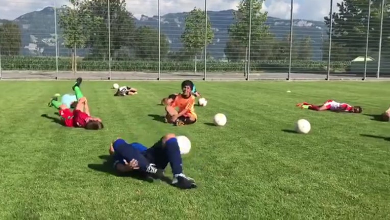 Youth soccer players practice dramatic diving screaming in