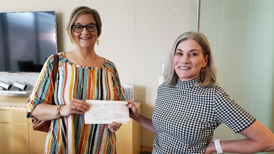 two women holding check