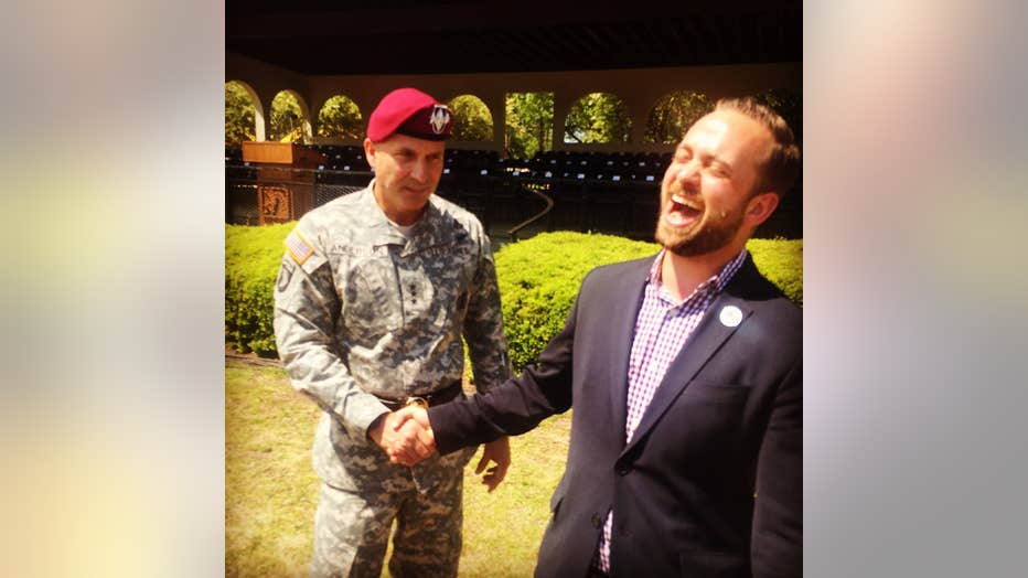 Garrett Cathcart smiles while shaking an Army officer's hand