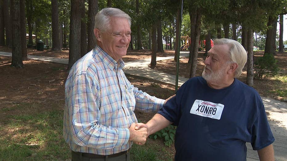 two men shaking hands laughing