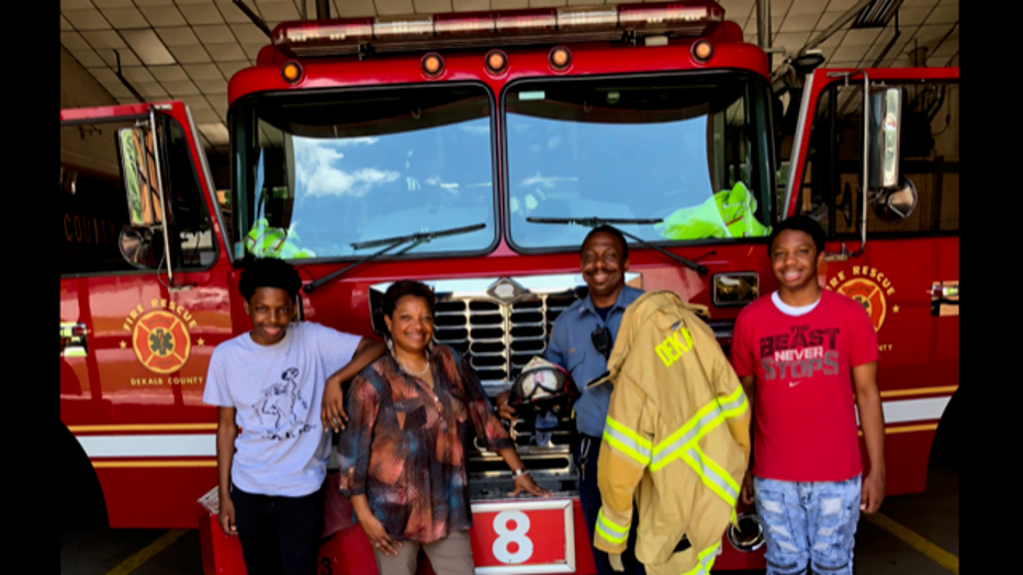 Captain Eric Jackson and his family stand in front of a firetruck at Station 8.