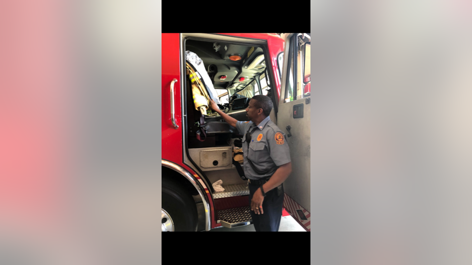 Captain Eric Jackson stands next to firetruck at Station 8.