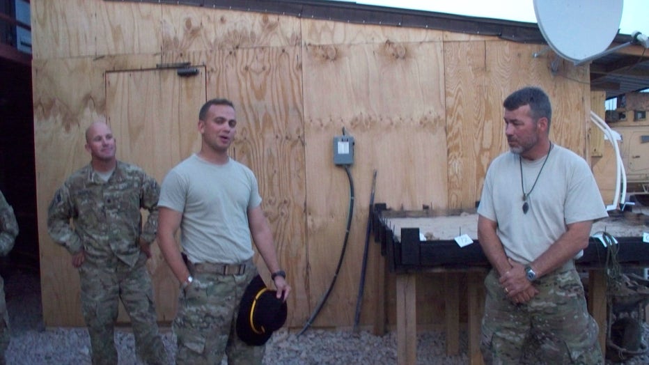 Garrett Cathcart talks with soldiers on a compound in Iraq.