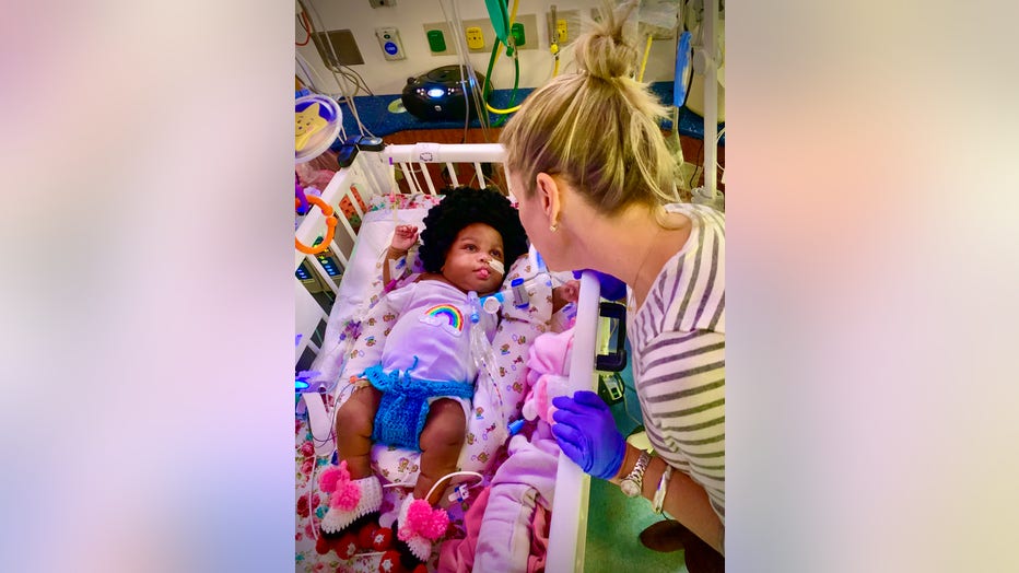 Children's Healthcare of Atlanta NICU nurse leans over baby dressed up as a