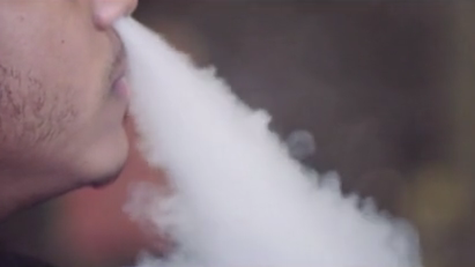 Man exhales nicotine vapor after using an e-cigarette