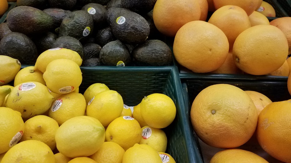 Grocery store bins of lemons, avocados and grapefruit