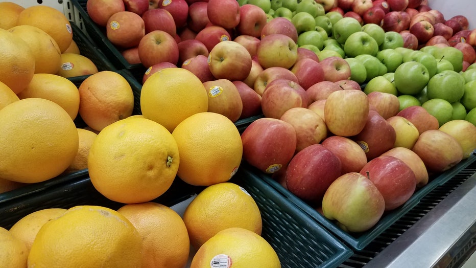 Grocery store bins of oranges and apples