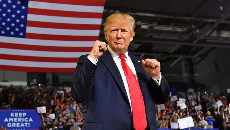 US President Donald Trump pumps his fists as he arrives for a 