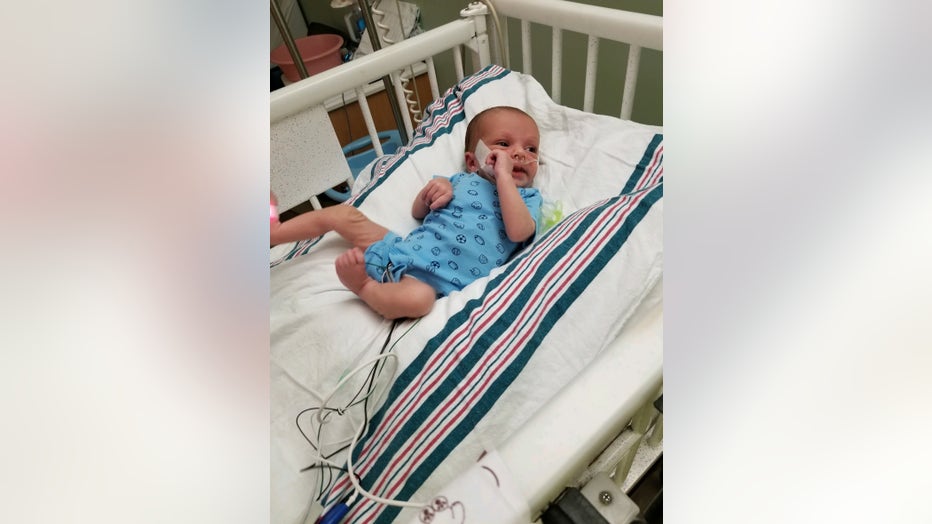 Baby lies in a hospital crib