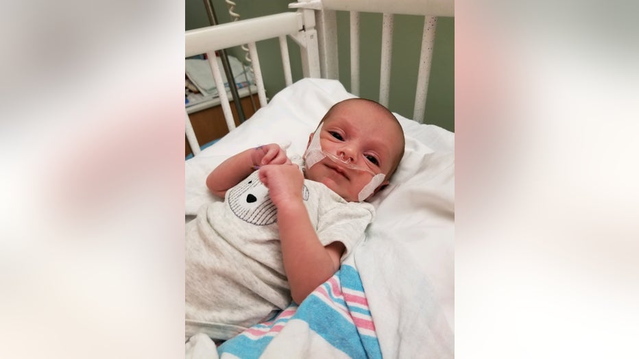 Baby lies in hospital crib