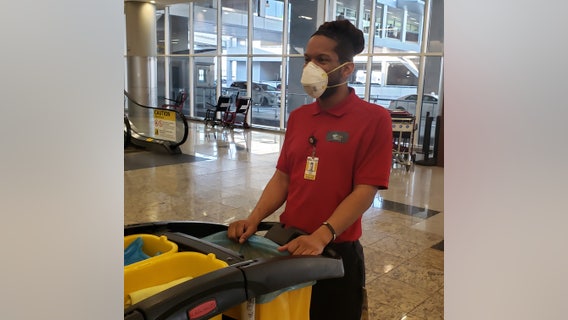Workers, airport travelers don masks out of concerns about deadly coronavirus
