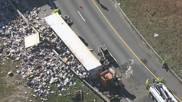 Tractor-trailer carrying trash overturns on I-285