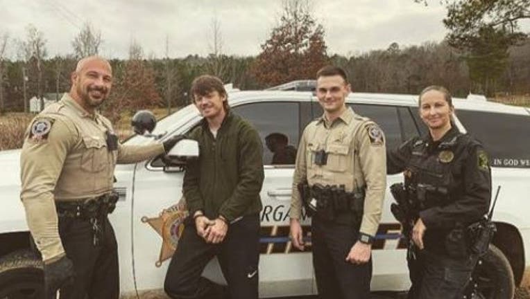 Heath Swafford poses with deputies who have just arrested him. (Morgan County Sheriff’s Office)