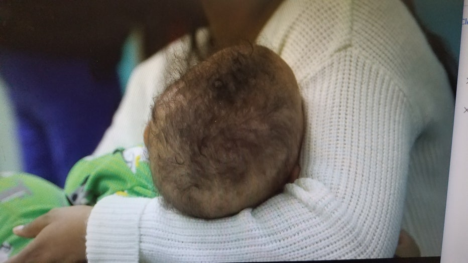 Mother holds baby in ER waiting room