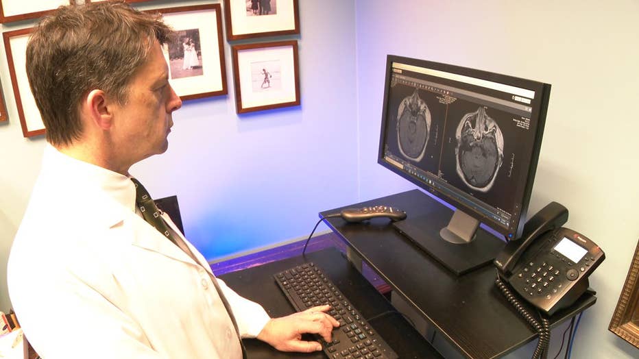 Doctor looks at images of patient's brain.