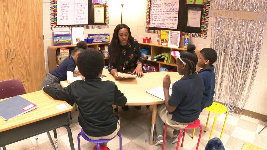 woman teaches group of students at table