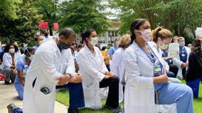 Emory health care workers kneel in a show of solidarity