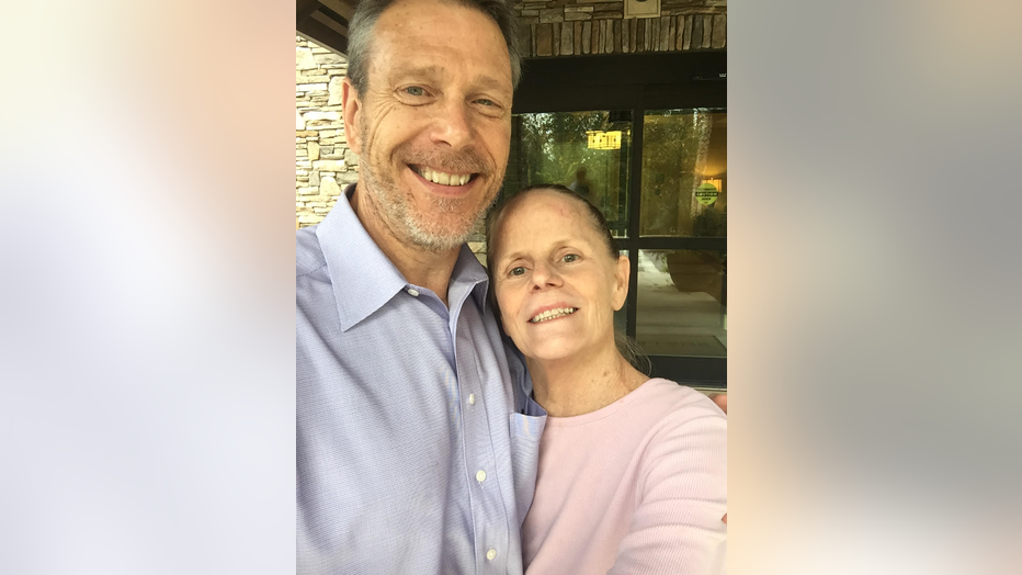 Man and woman hug while taking a photo.