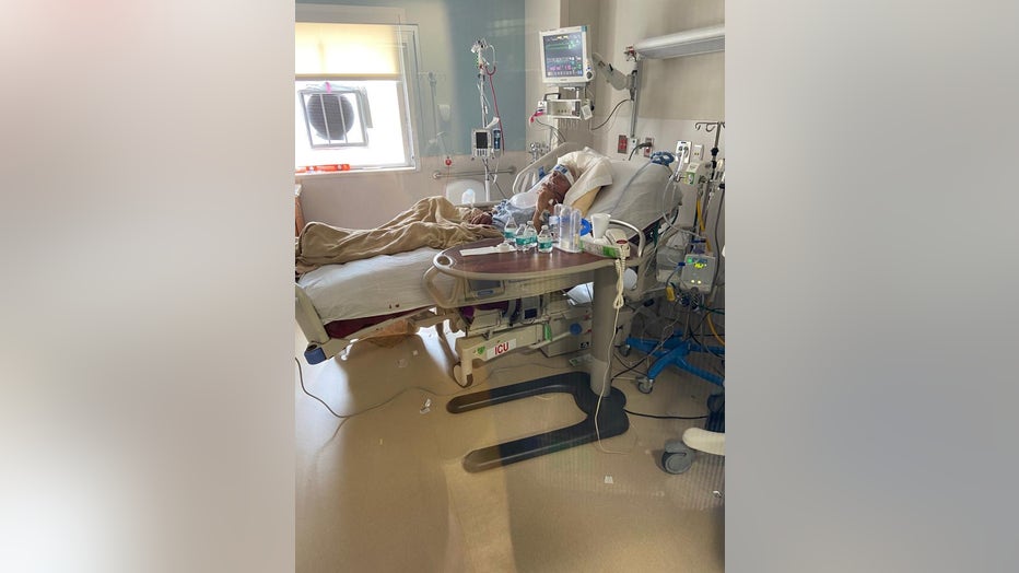Older man lies in an ICU bed of a hospital.