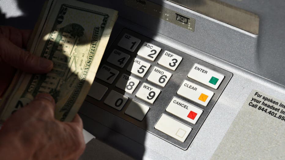 FILE - A banking customer withdraws money from a ATM machine in Santa Fe, New Mexico. 