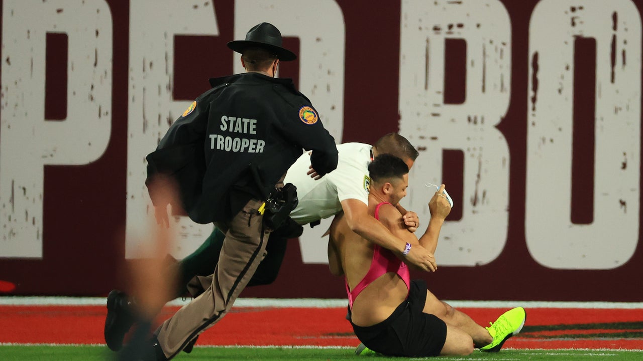 Streaker: Fan in pink one-piece runs on field during Super Bowl LV