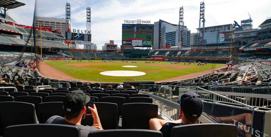 ATLANTA, GA - AUGUST 21: Fans line up to get inside Truist Park at The Chop  House Gate in The Battery Atlanta prior to the Sunday afternoon MLB game  between the Houston