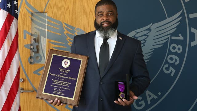 Officer struck by ATV during protest stands to receive Purple Heart