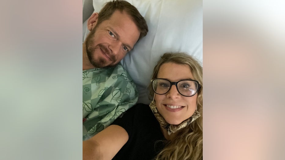 Couple in hospital bed poses for a selfie.
