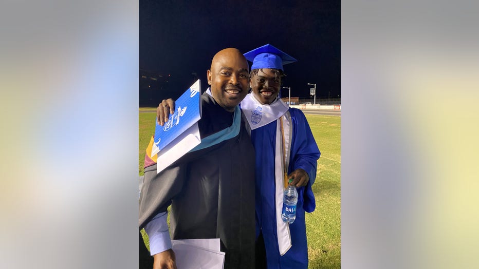 Father and son pose at high school graduation
