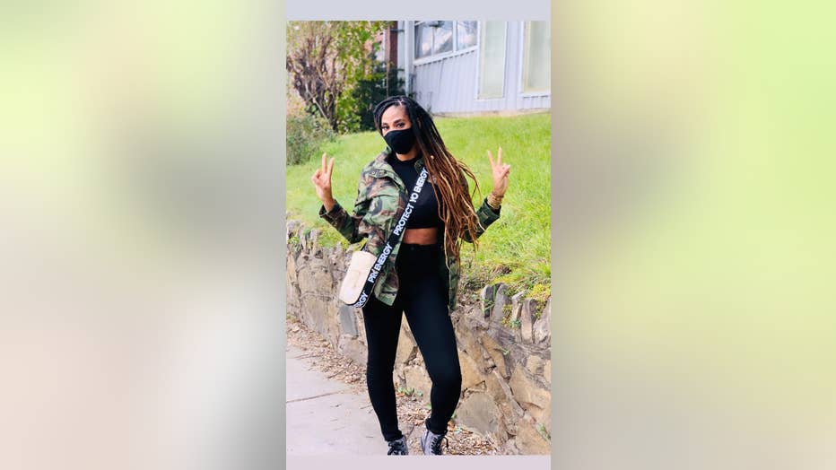 Black woman with long hair gives peace sign 