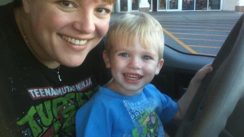 Woman and young son sit in car.