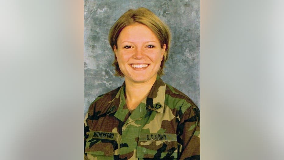 Woman in military uniform smiles for official photo