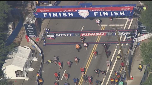 AJC Peachtree Road Race winners cross finish line
