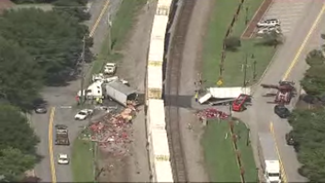 Tractor trailer collides with train, closes roadway in Buford