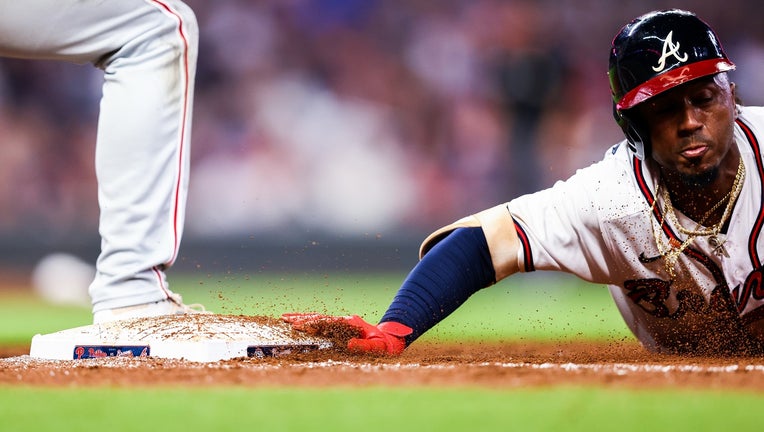 Ozzie Albies #1 of the Atlanta Braves dives back to first base on a pickoff attempt during game 2 of a series between the Atlanta Braves and the Philadelphia Phillies at Truist Park on September 29, 2021 in Atlanta, Georgia. (Photo by Casey Sykes/Getty Images)