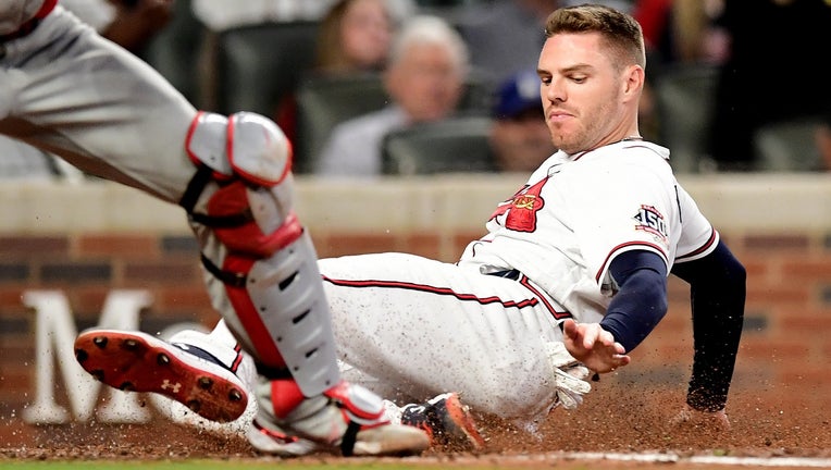 Freddie Freeman #5 of the Atlanta Braves slides safely into home on a triple hit by Ozzie Albies (not shown) during the fifth inning against the Philadelphia Phillies at Truist Park on September 30, 2021 in Atlanta, Georgia. (Photo by Adam Hagy/Getty Images)