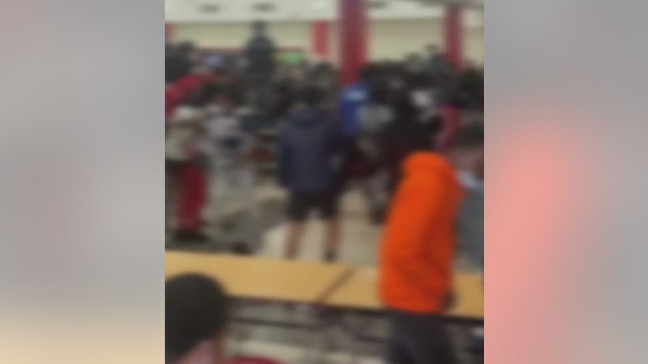 This blurred image shows a fight at Tri-Cities High School.