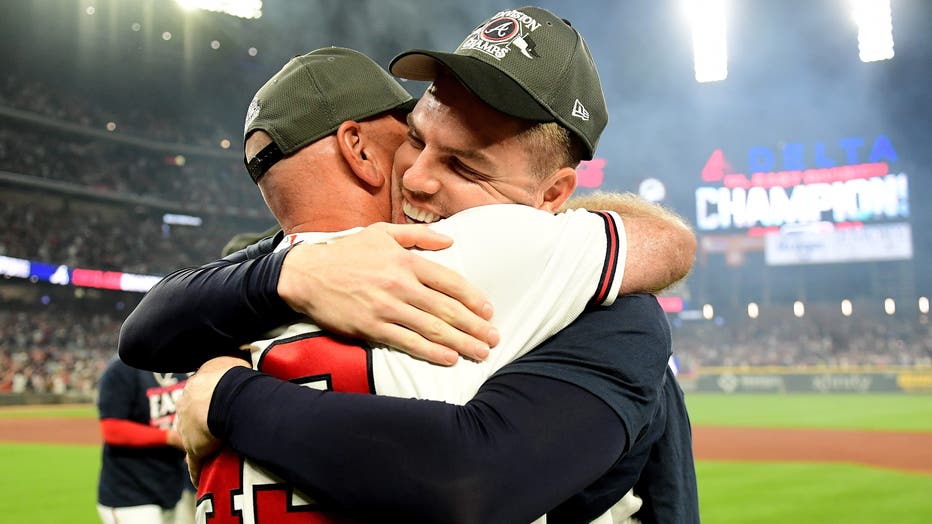 Freddie Freeman #5 of the Atlanta Braves hugs Brian Snitker #43 of the Atlanta Braves after winning the NL Eastern Division against the Philadelphia Phillies at Truist Park on September 30, 2021 in Atlanta, Georgia. (Photo by Adam Hagy/Getty Images)