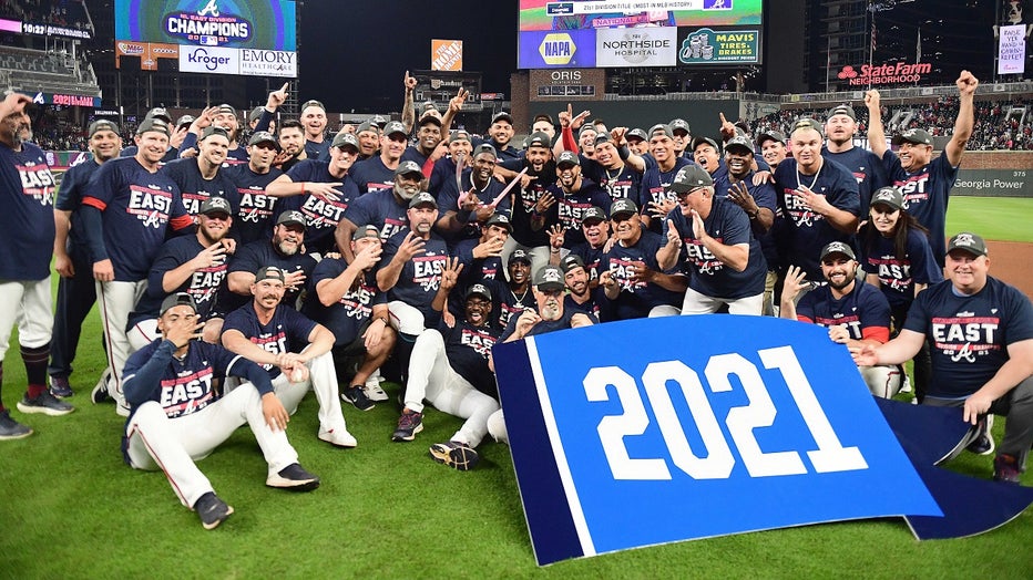 The Atlanta Braves celebrate after winning the NL Eastern Division against the Philadelphia Phillies at Truist Park on September 30, 2021 in Atlanta, Georgia. (Photo by Adam Hagy/Getty Images)