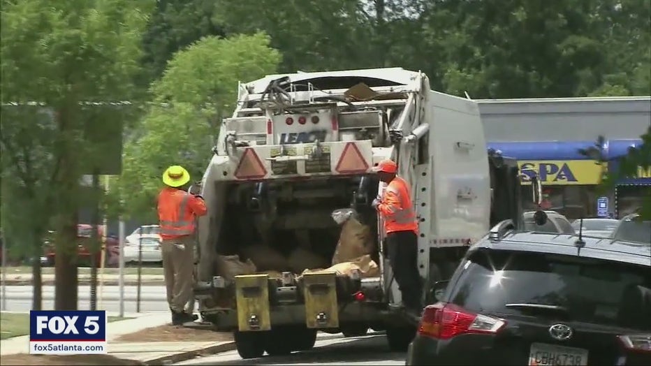 Sanitation workers with the city of Atlanta work their usual route to pick up trash and yard debris around the city on Sept. 20, 2021.