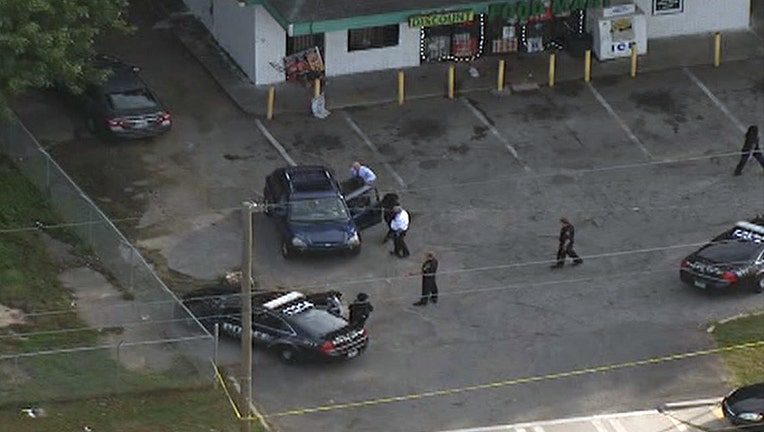 Investigators focus on a car in the parking lot of a food mart along Glenwood Avenue following a shooting on Oct. 14, 2021.