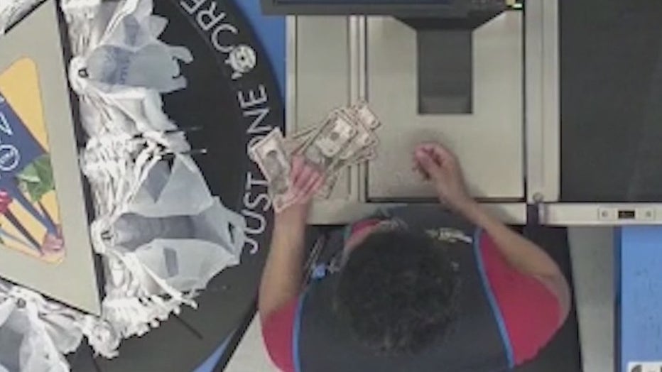 A Walmart clerk looks over $10 bills used to make a purchase in Athens.