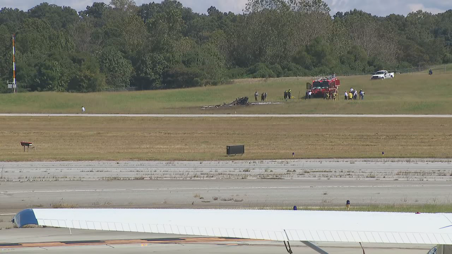 Firefighters inspect the remains of a burned plane at DeKalb-Peachtree Airport on Oct. 8, 2021.