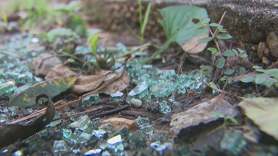 Shards of glass from shattered vehicle windows line a northeast Atlanta street.