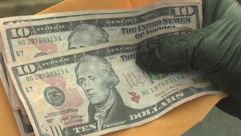 Athens police show two ten-dollar bills with the same serial number used at an area Walmart.