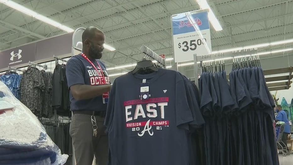 An employee at Academy Sports and Outdoors restocks Braves merchandise after the fourth-straight NL East Title on Oct. 1, 2021.